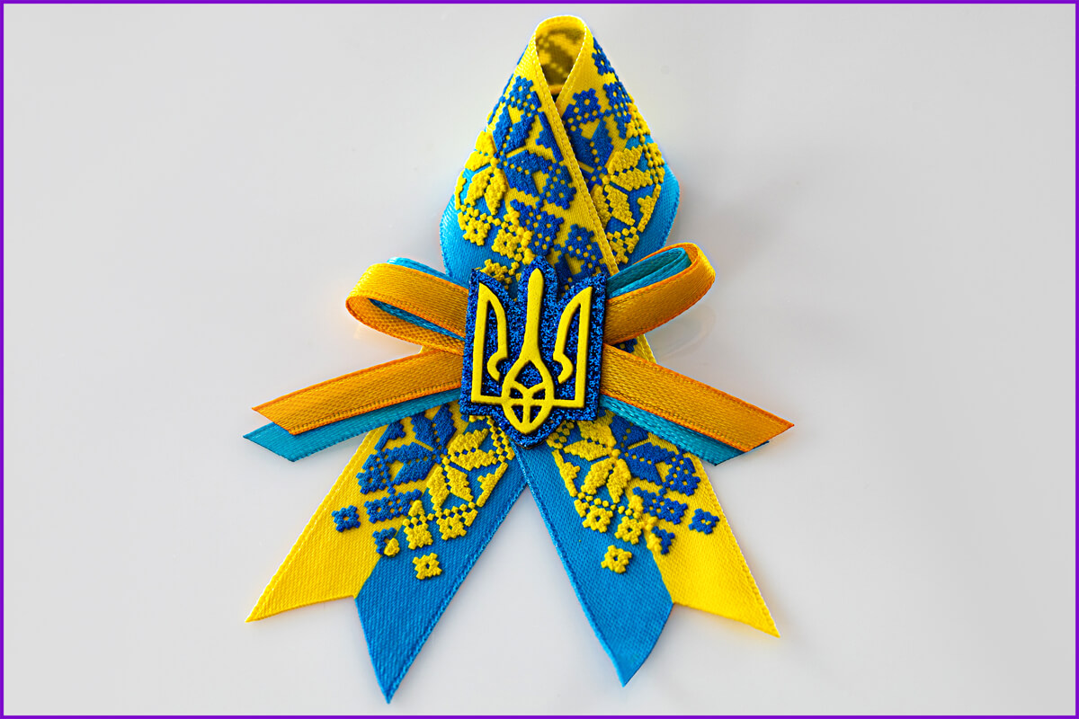 Желто голубого цвета брошь с орнаментом и гербом