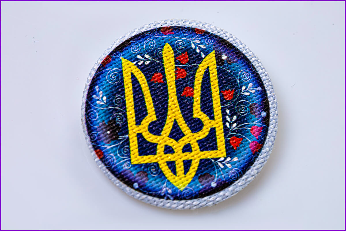 На тканевой льняной основе значок герб  в орнаменте